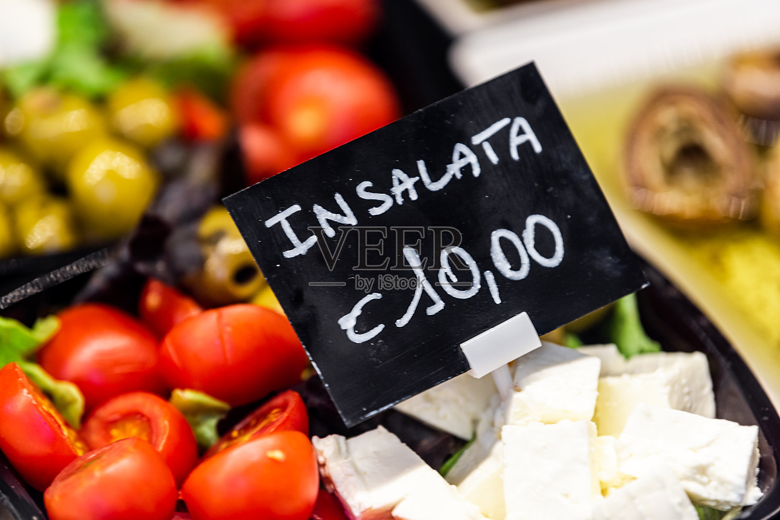 在著名的意大利佛罗伦萨佛罗伦萨中央Mercato,包装沙拉展示蕃茄,橄榄和羊乳酪的特写,并标有昂贵的价格照片摄影图片