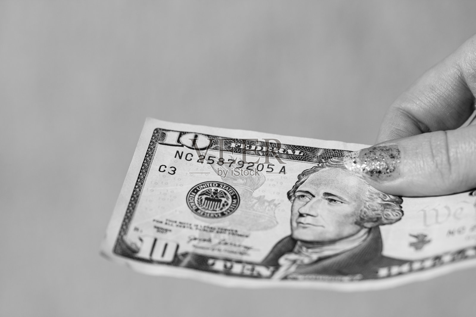 手递钱,类似贿赂或小费。在模糊的背景下拿着美元钞票,美国货币照片摄影图片