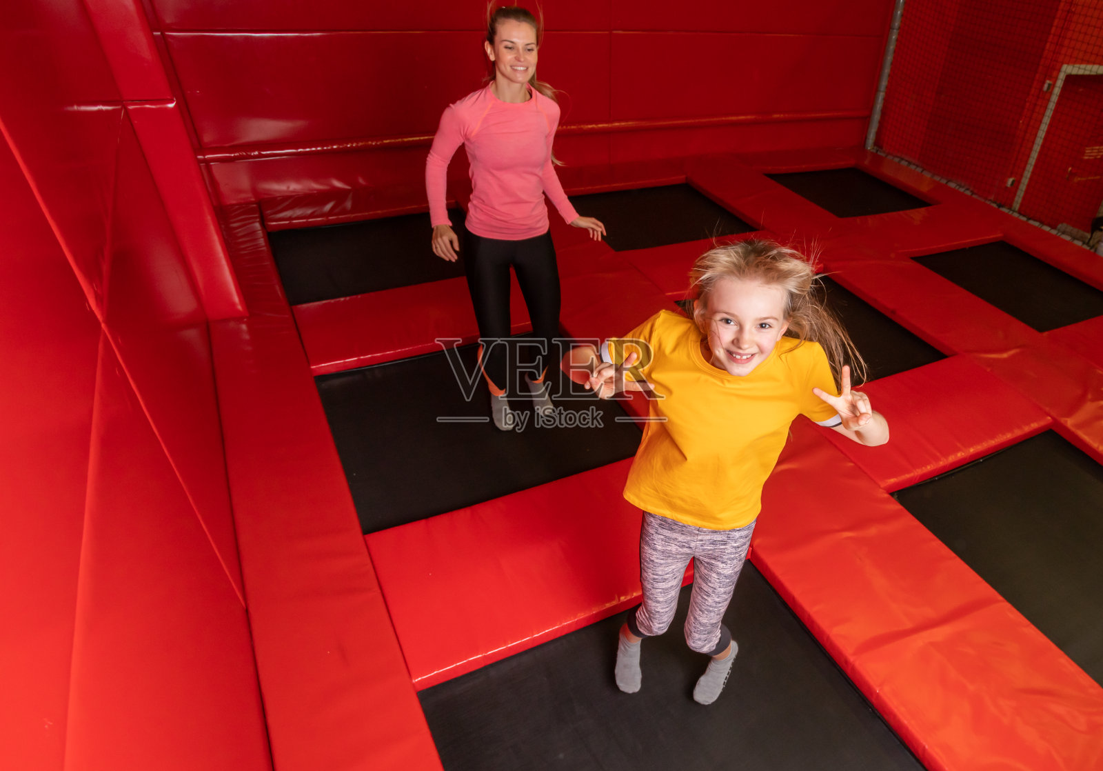 快乐的一家人在蹦床上玩耍照片摄影图片