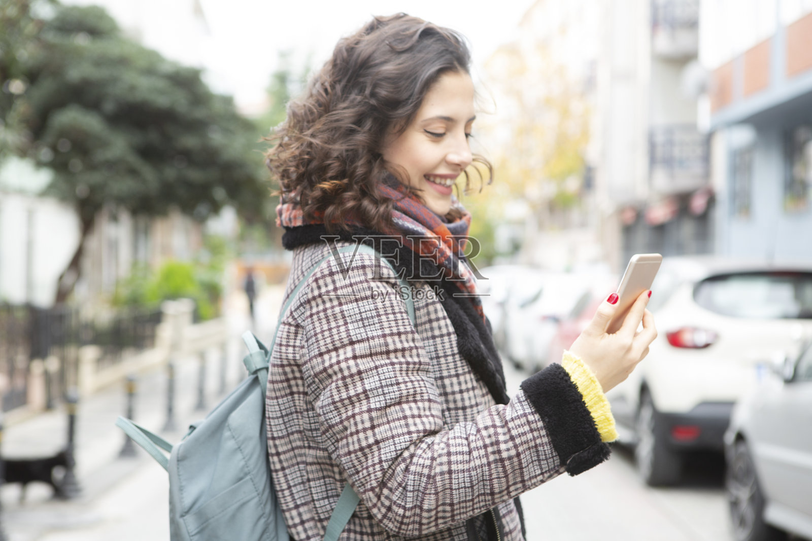 在街上用手机的快乐女孩照片摄影图片