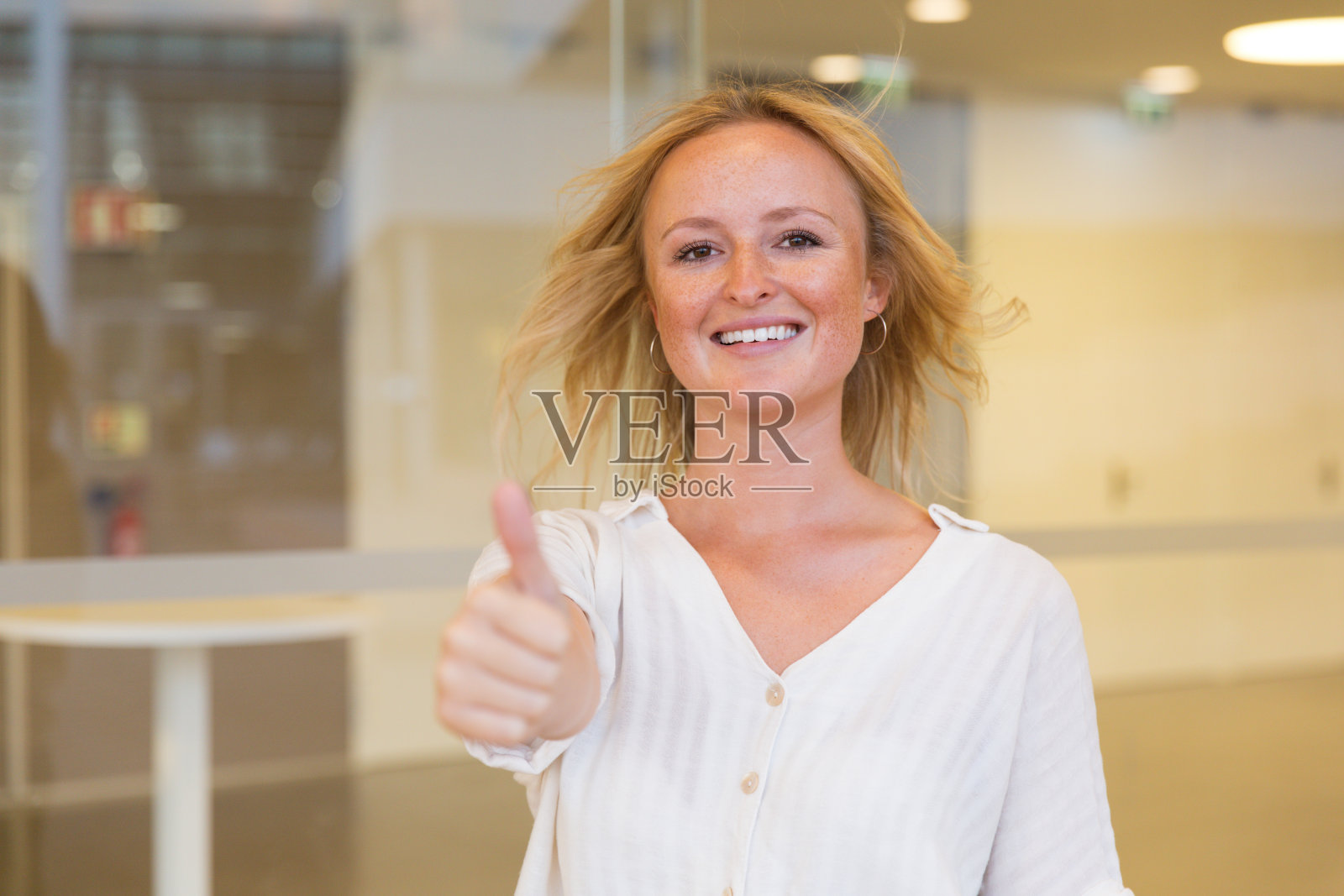 快乐的金发女人竖起大拇指照片摄影图片