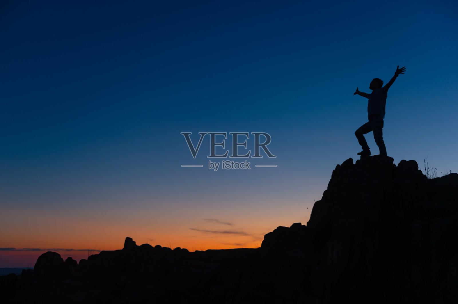 年轻男人在悬崖顶上享受成功照片摄影图片