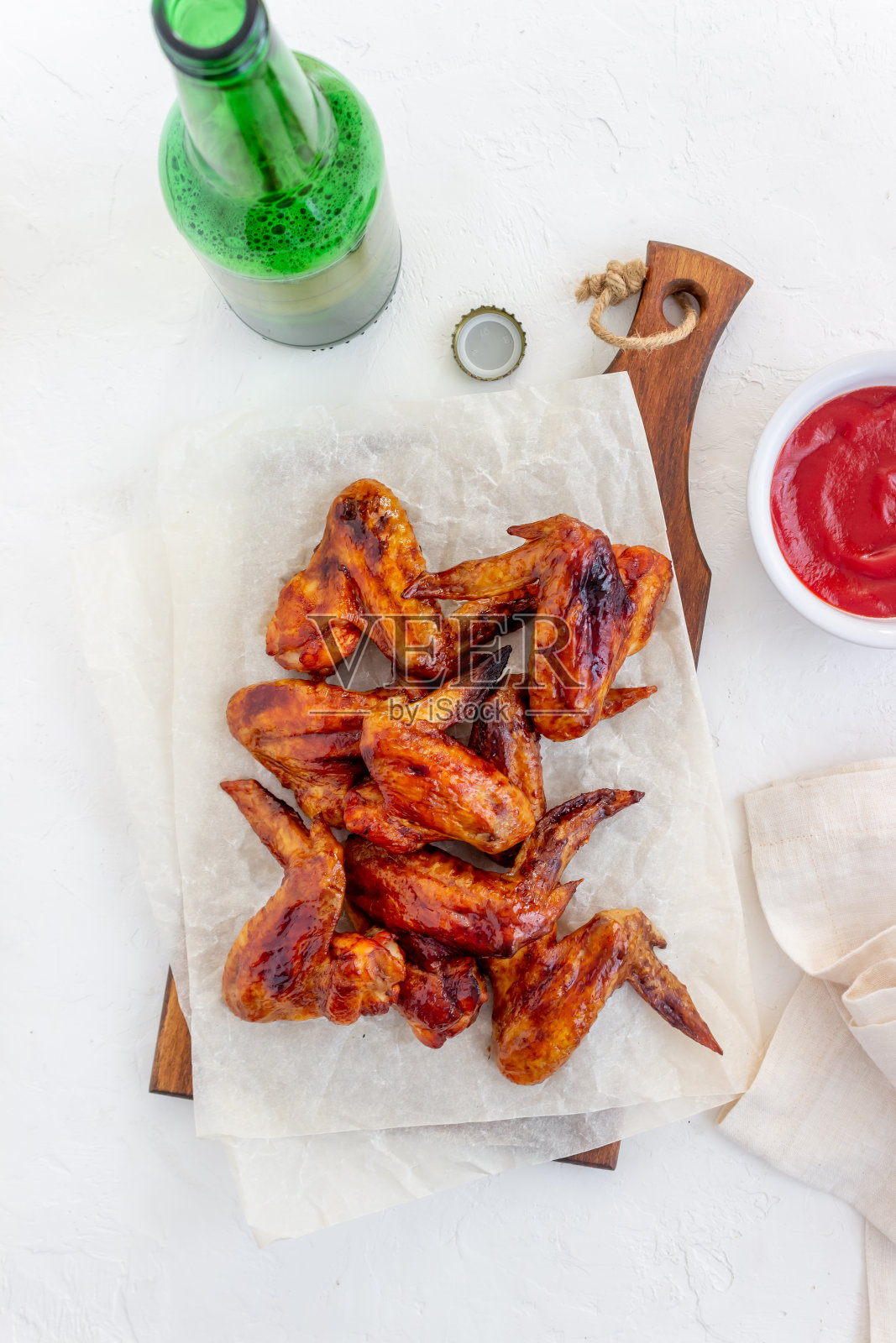 白底烤鸡翅和啤酒。小吃,啤酒。烧烤。菜谱。照片摄影图片
