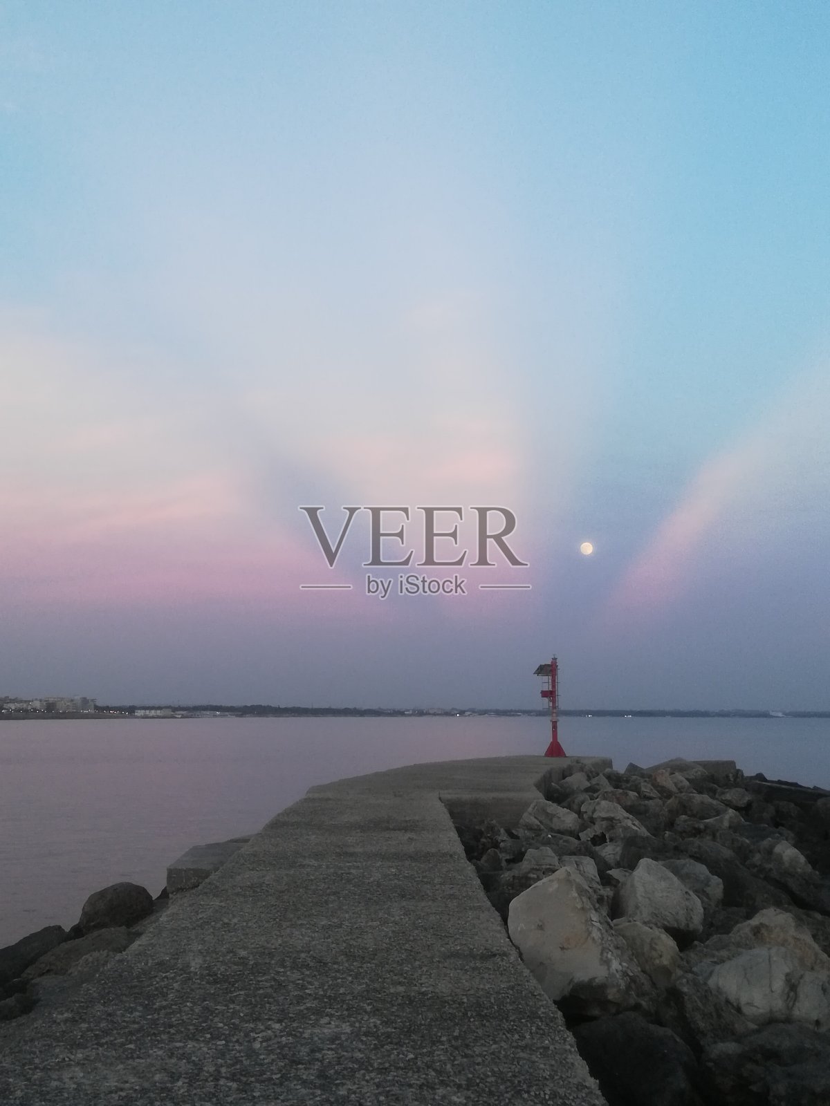 粉红色阳光下的灯塔、月亮和码头照片摄影图片