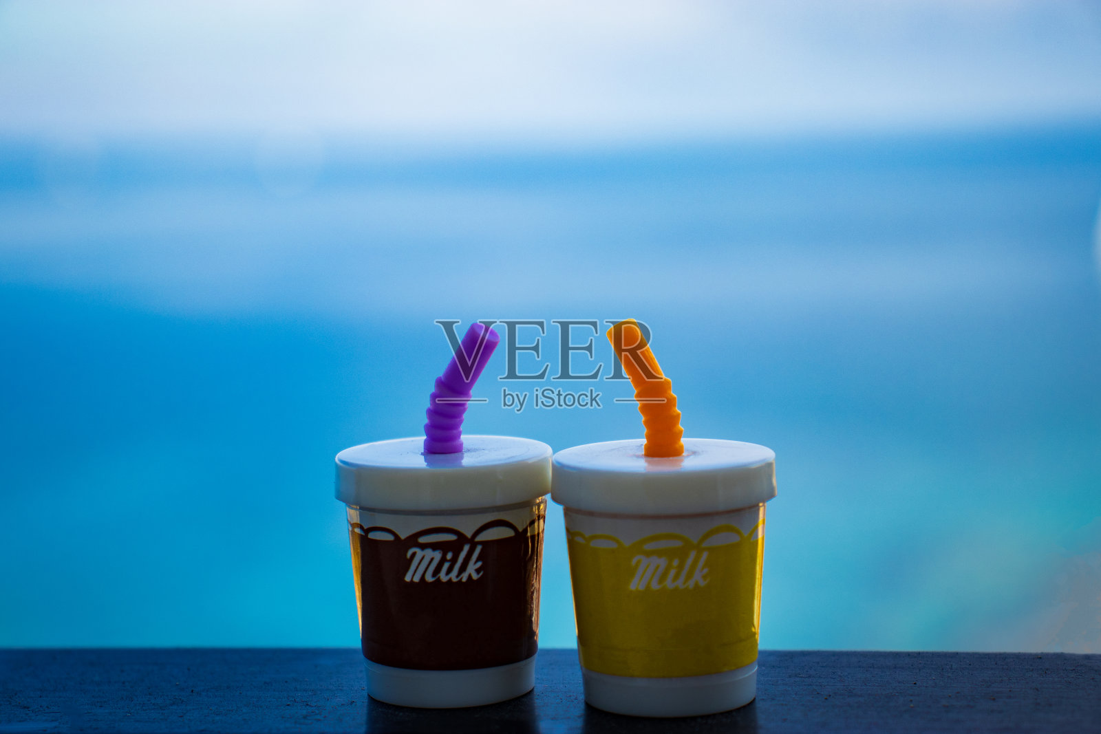 两杯奶昔,背景是蓝色的大海。典型的度假的感觉照片摄影图片