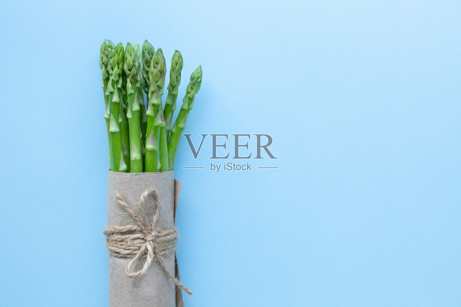 蓝色背景下一束新鲜的绿色芦笋照片摄影图片