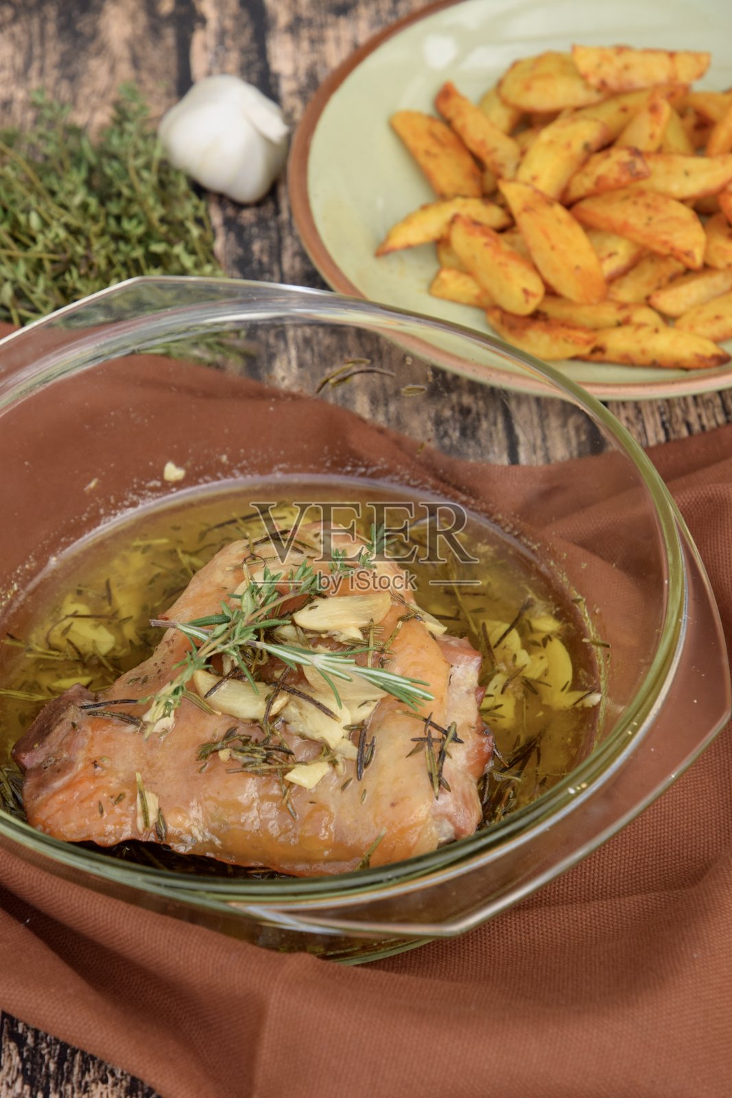 烤鸡腿配蒜和迷迭香。配炸薯条或炸土豆条照片摄影图片