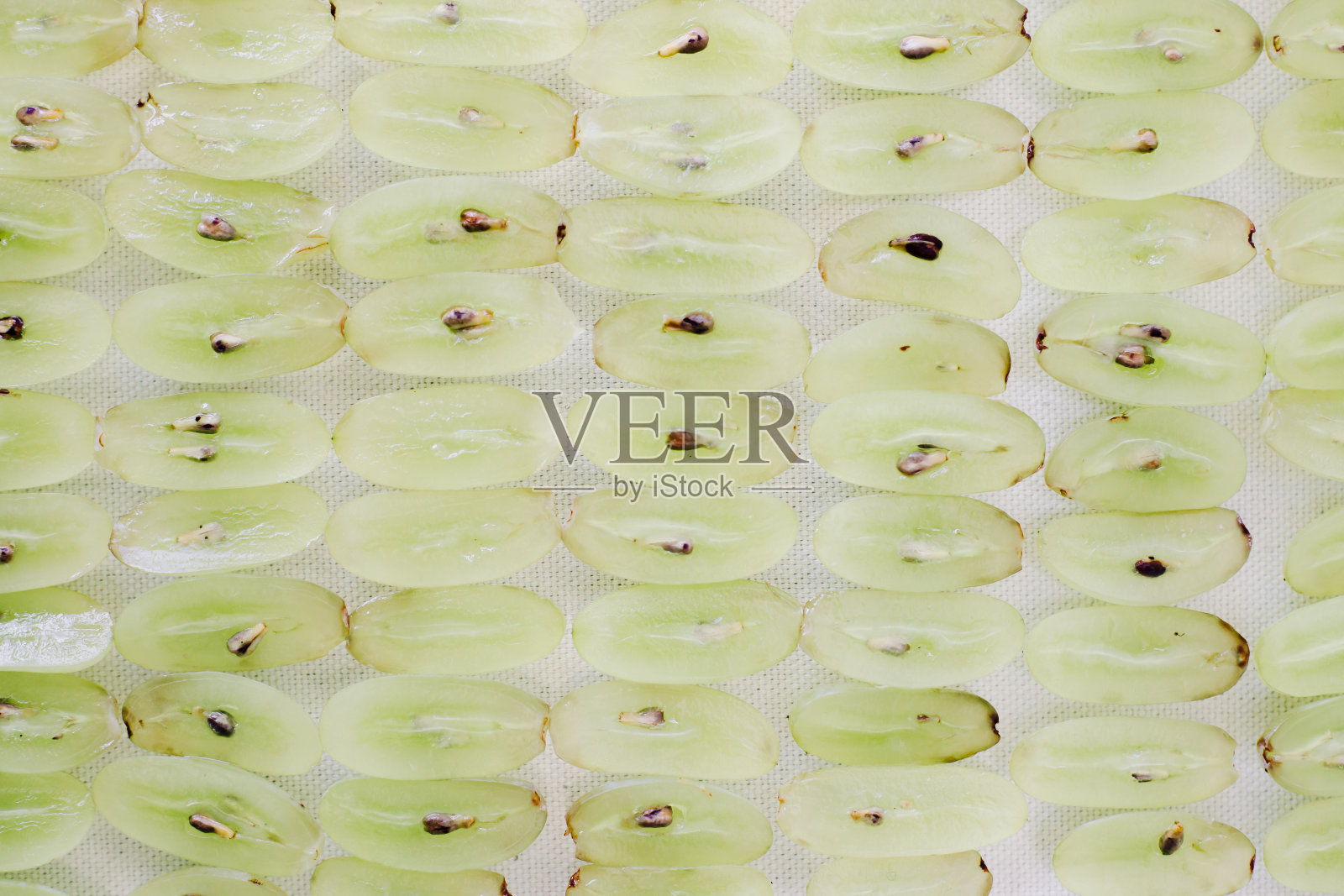 白色的桌子上放着切成两半的成熟葡萄。夏季照片摄影图片