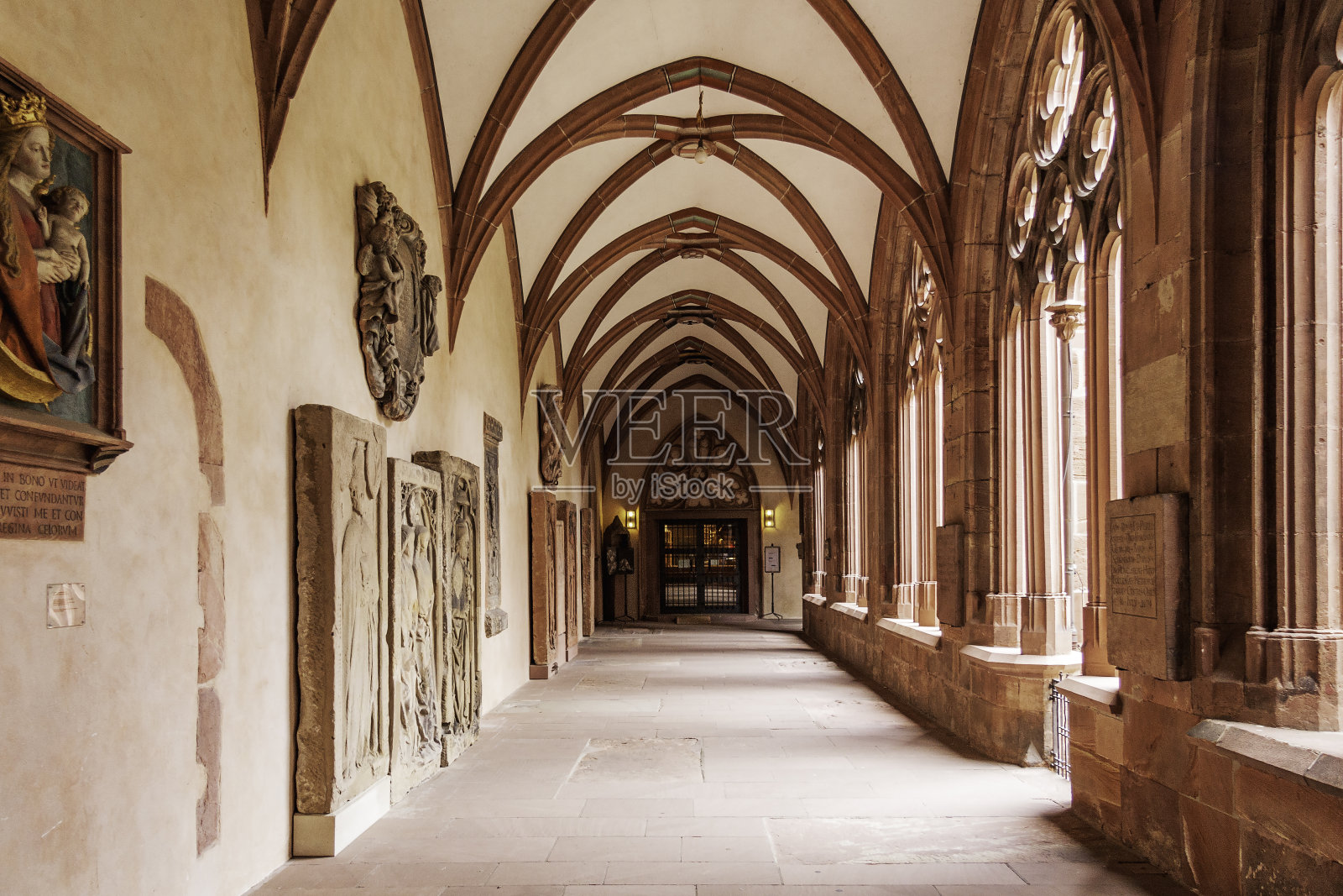 圣马丁大教堂或美因茨大教堂的拱形通道,一面墙上有石雕,另一面有罗马风格的石雕门道和石雕窗,都通向一个入口照片摄影图片