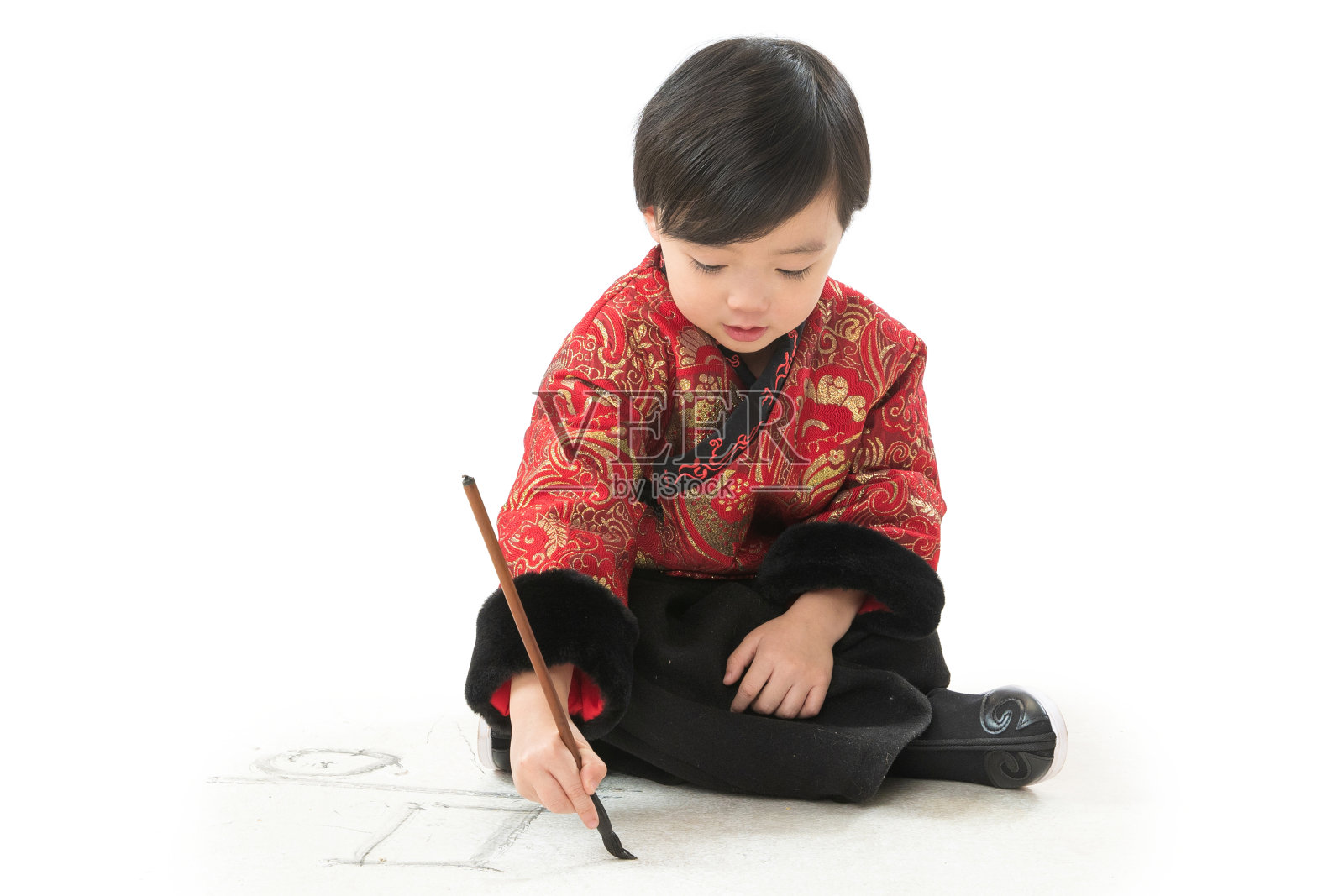 可爱的小男孩坐在地上画画照片摄影图片