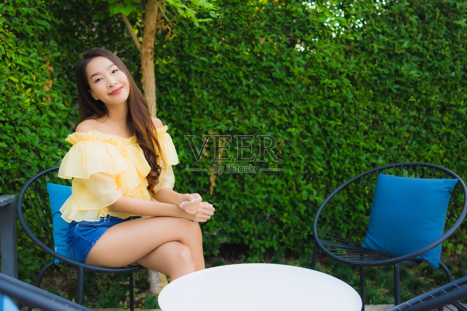 年轻的亚洲女人放松地坐在椅子上微笑照片摄影图片