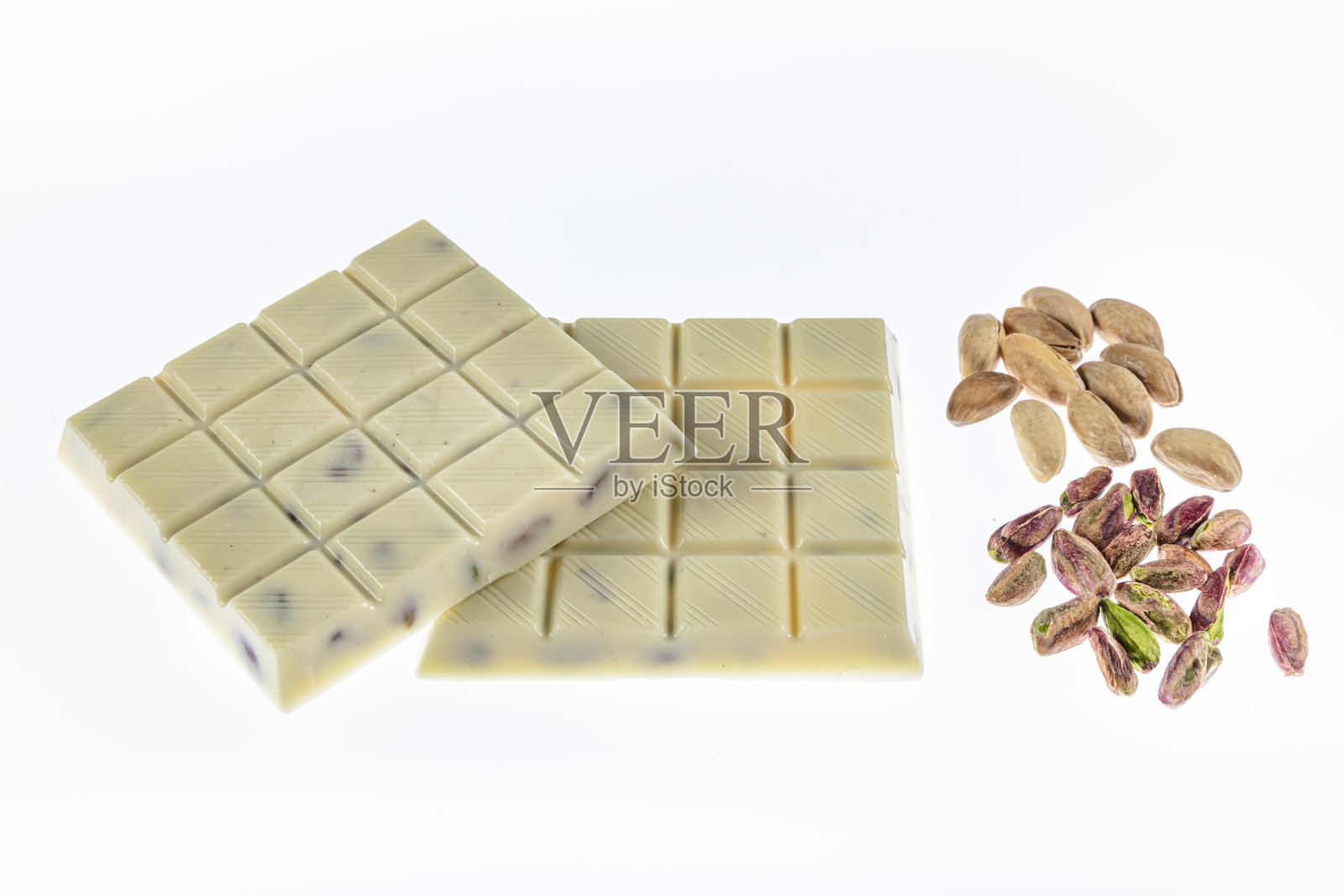 白巧克力与开心果孤立在白色背景。照片摄影图片