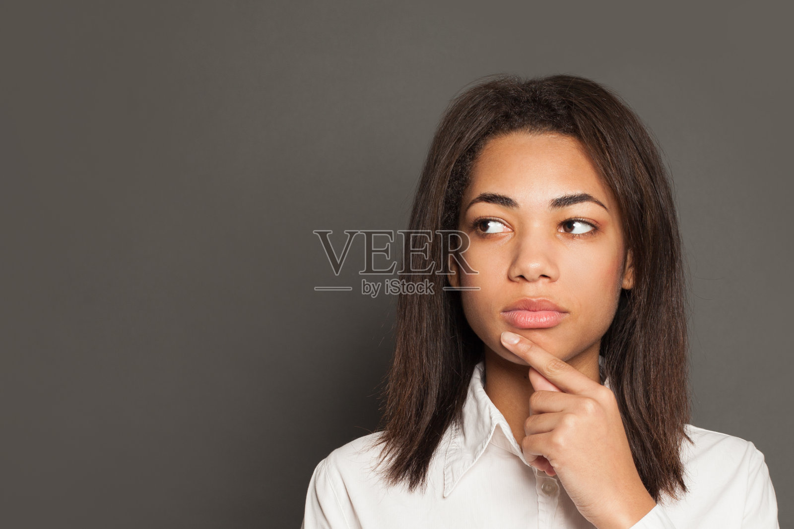在灰色背景下思考的非裔美国妇女照片摄影图片