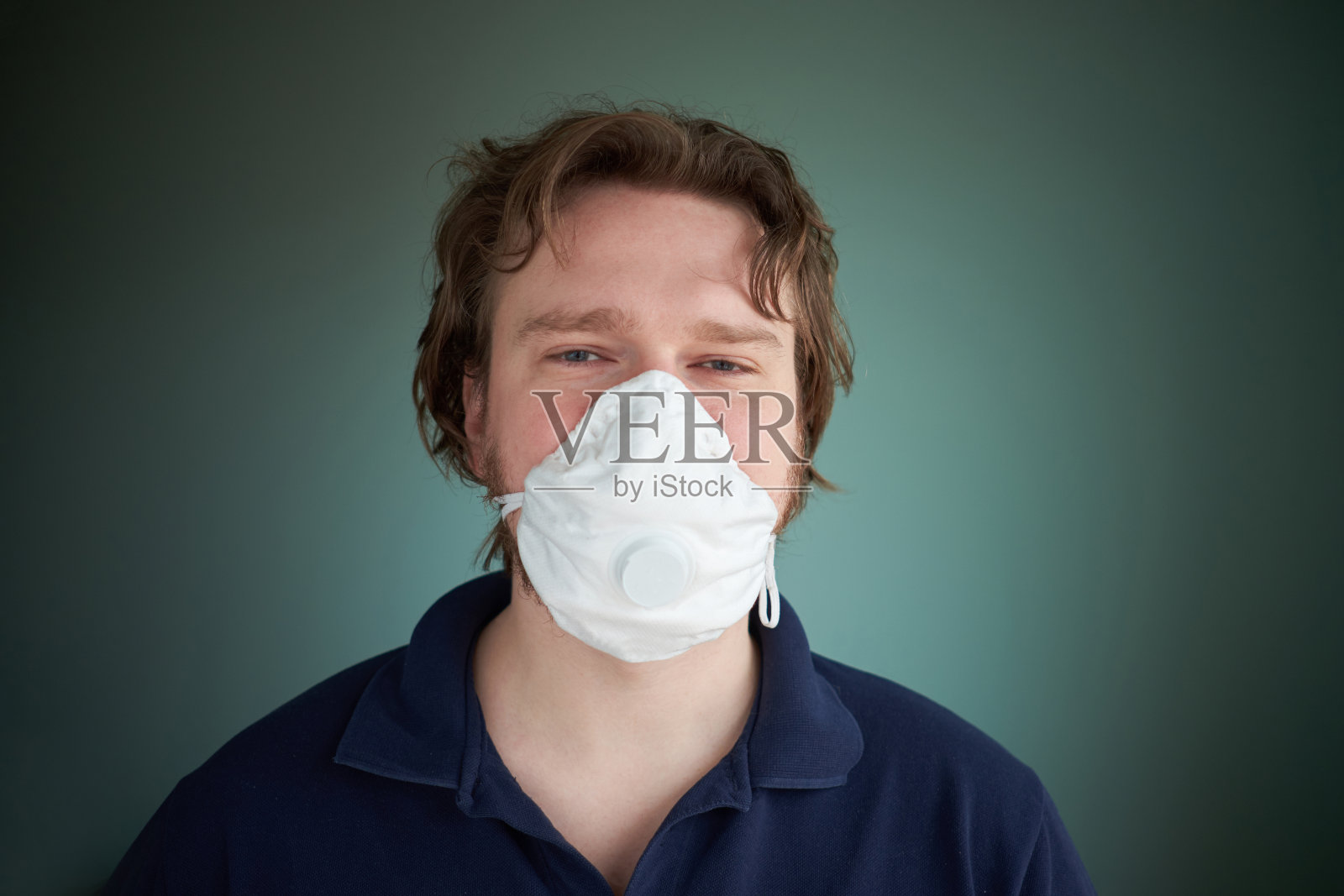 白人男子佩戴医用防护口罩,病毒疫情概念,绿色背景照片摄影图片