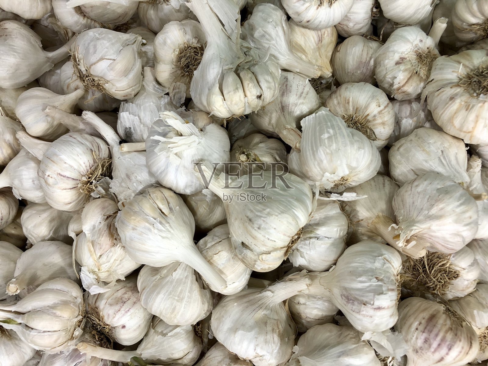 这是印度当地的新鲜农产品市场,近距离观察成堆的大蒜照片摄影图片