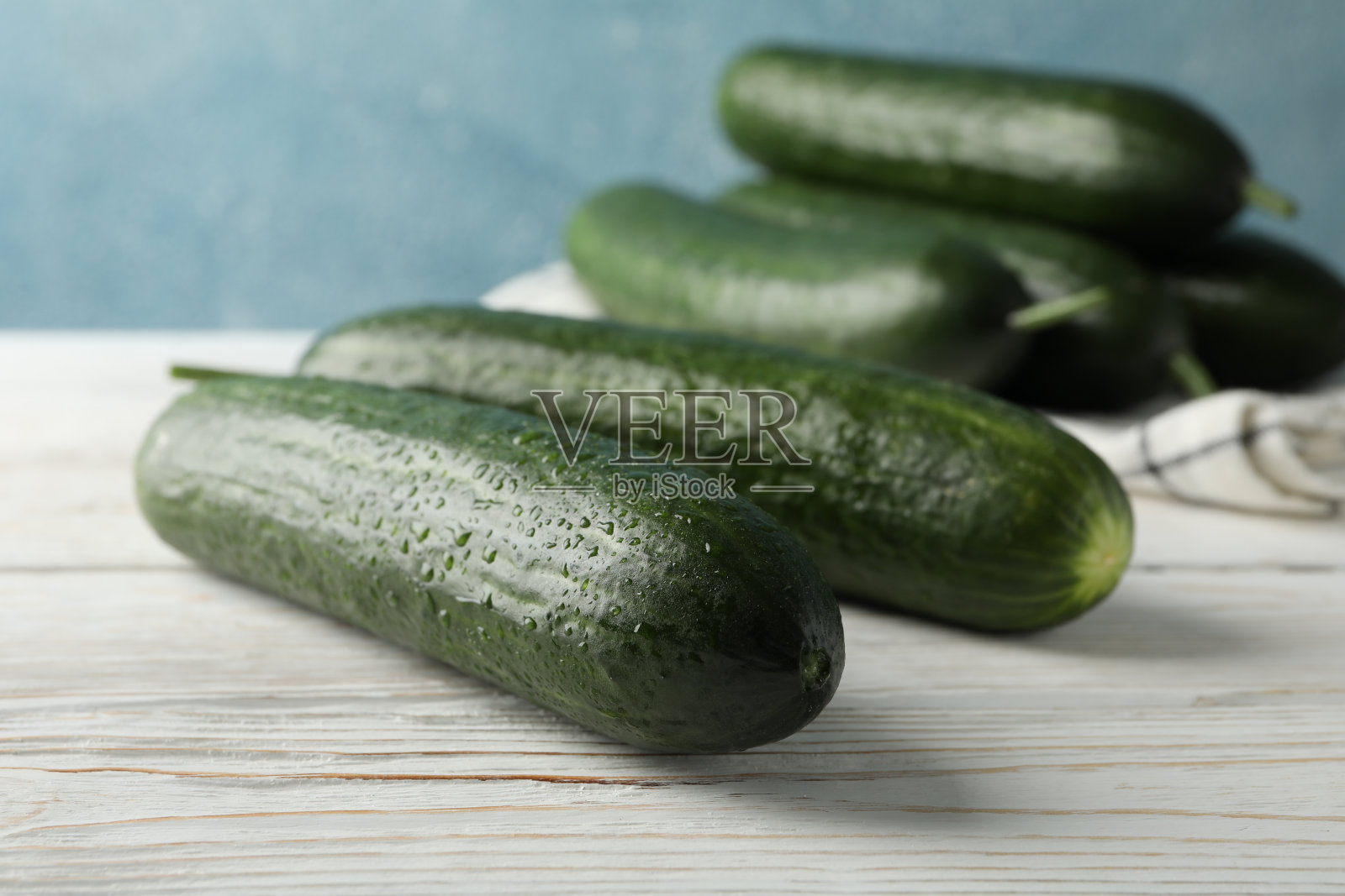 木头背景上有黄瓜和毛巾,特写照片摄影图片