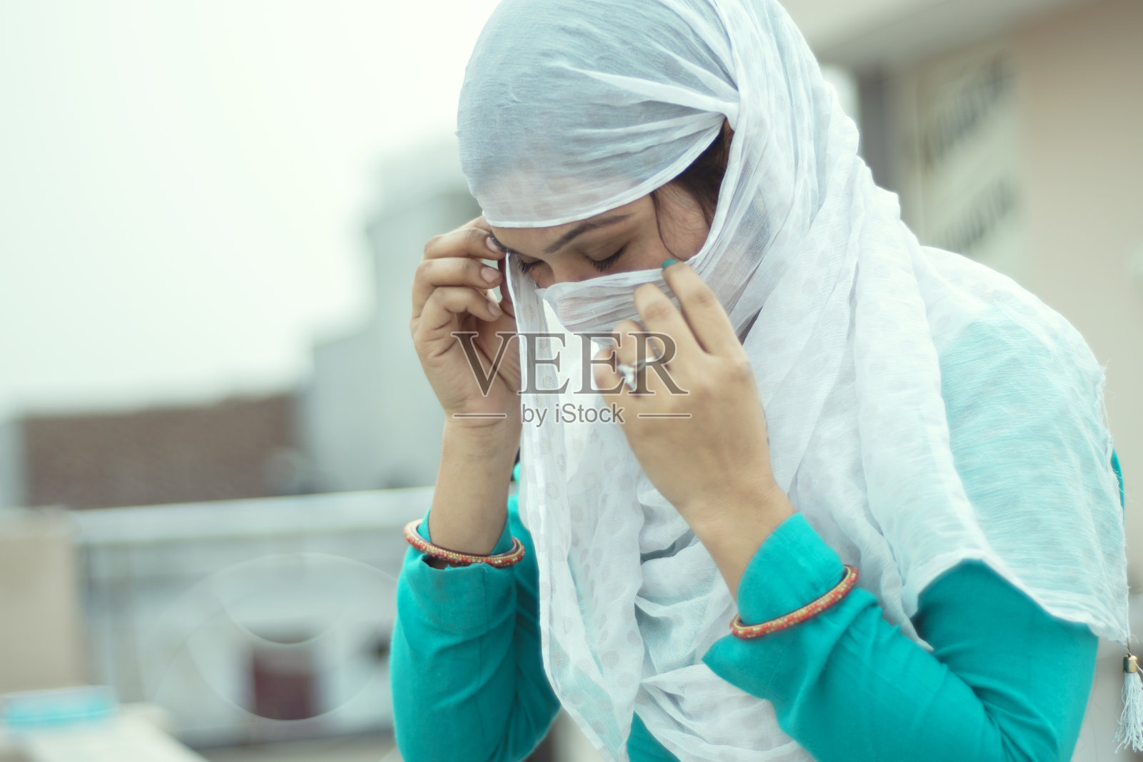 年轻女子用围巾遮住脸的肖像照片摄影图片