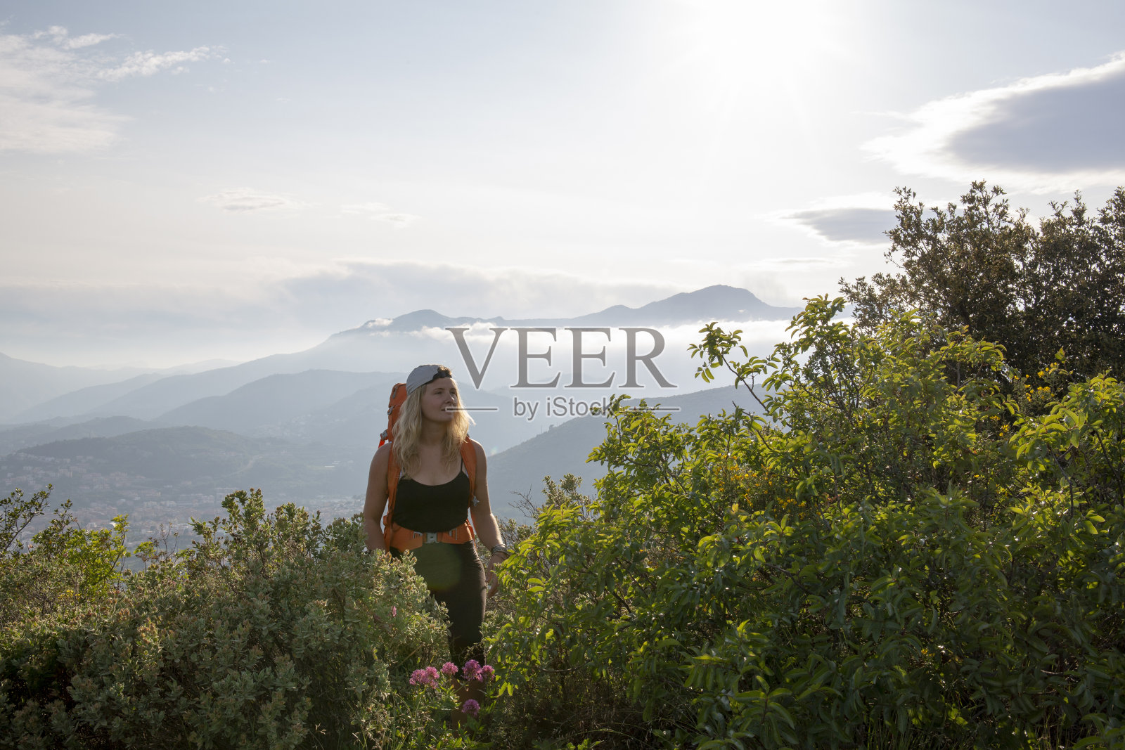 一个背着双肩包的年轻女子的肖像,在日出的时候照片摄影图片