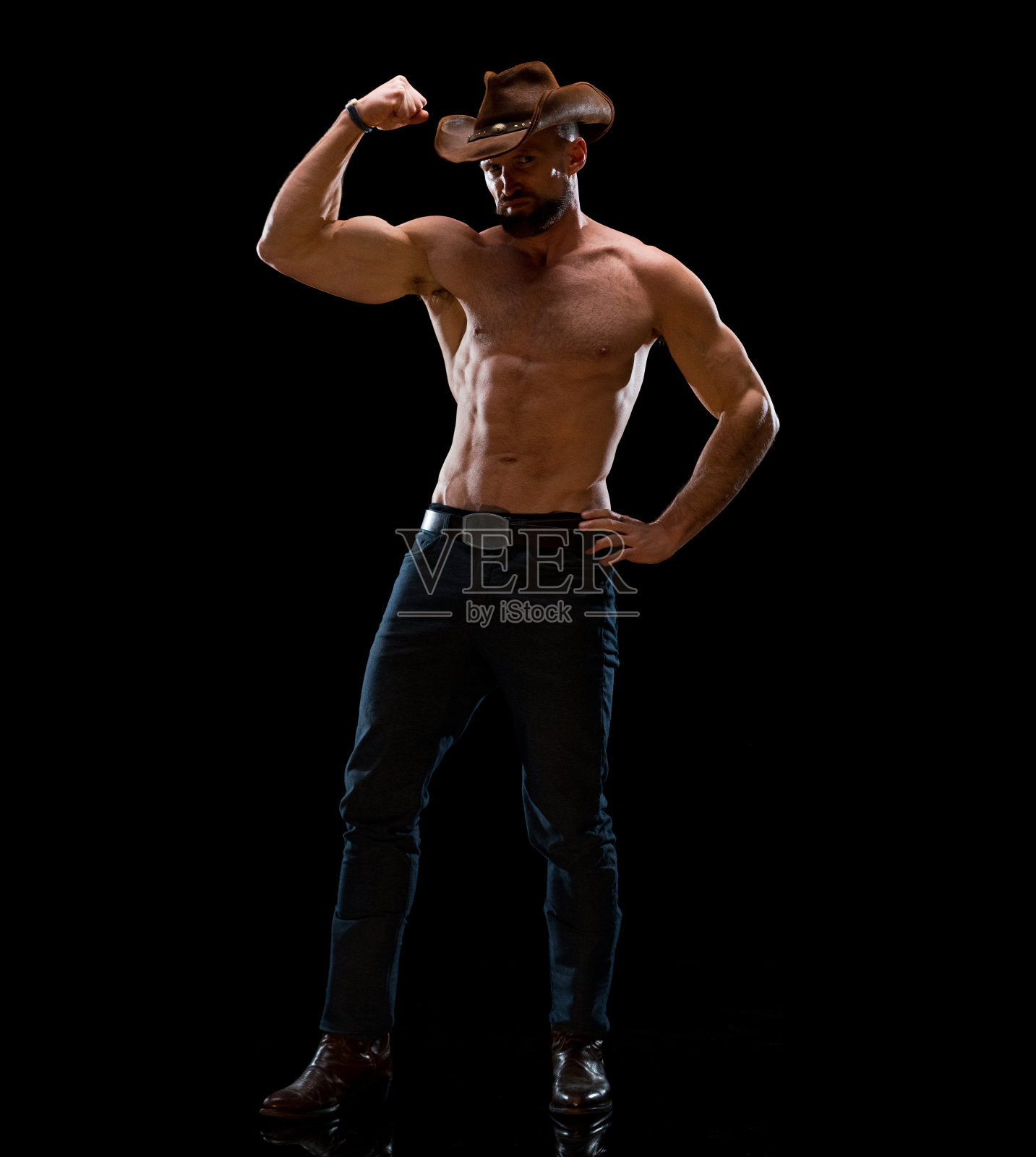戴牛仔帽站在黑色背景前的中年白人牛仔照片摄影图片