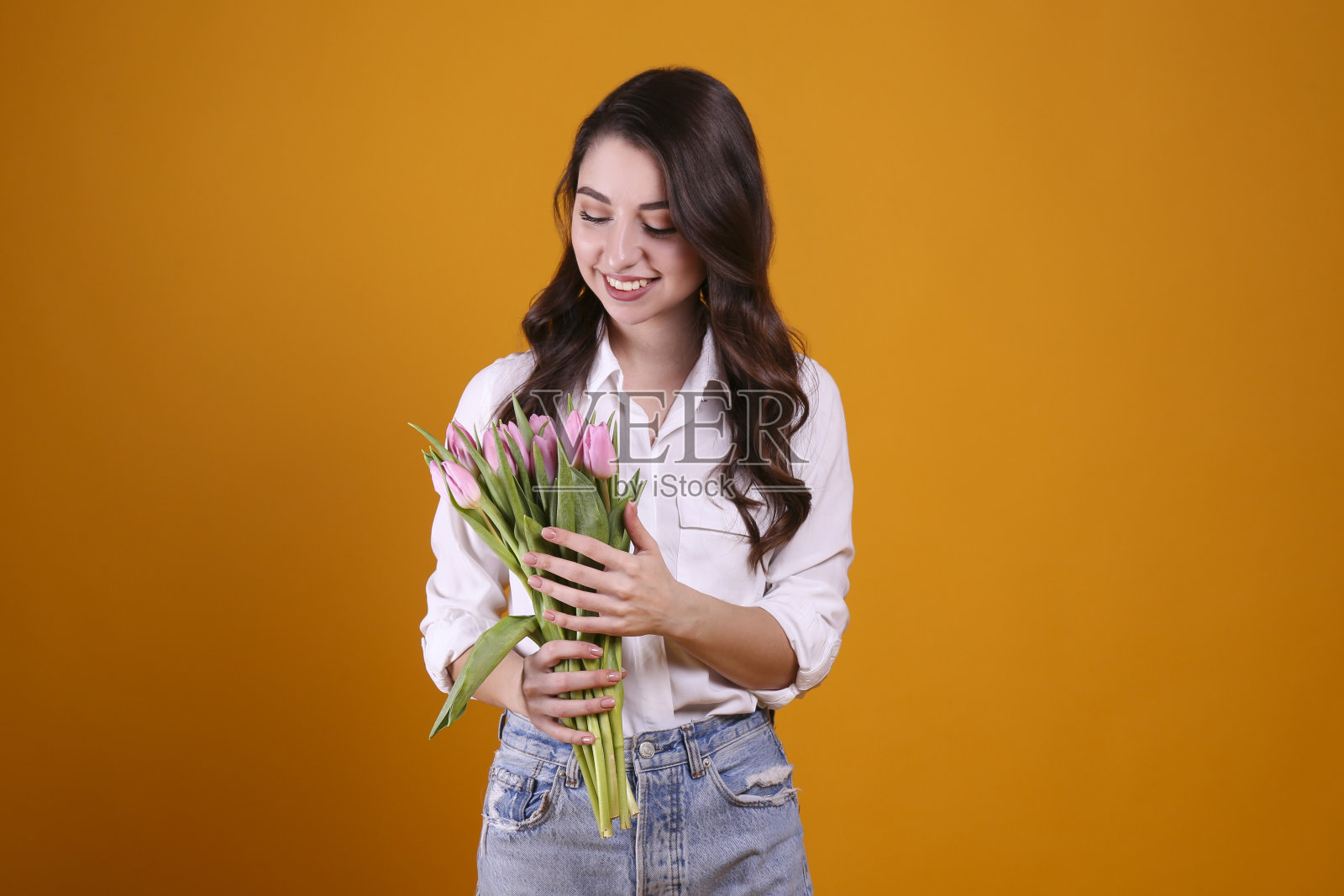 漂亮的女人拿着一束春季鲜花,庆祝国际妇女节照片摄影图片