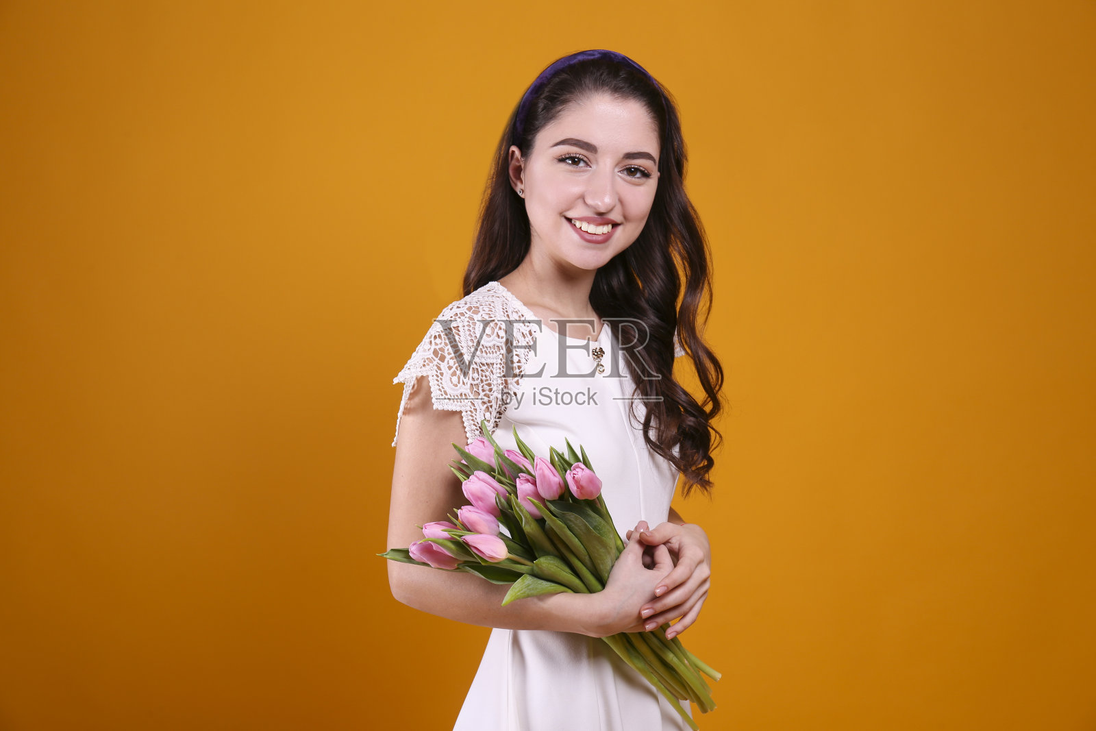 漂亮的女人拿着一束春季鲜花,庆祝国际妇女节照片摄影图片