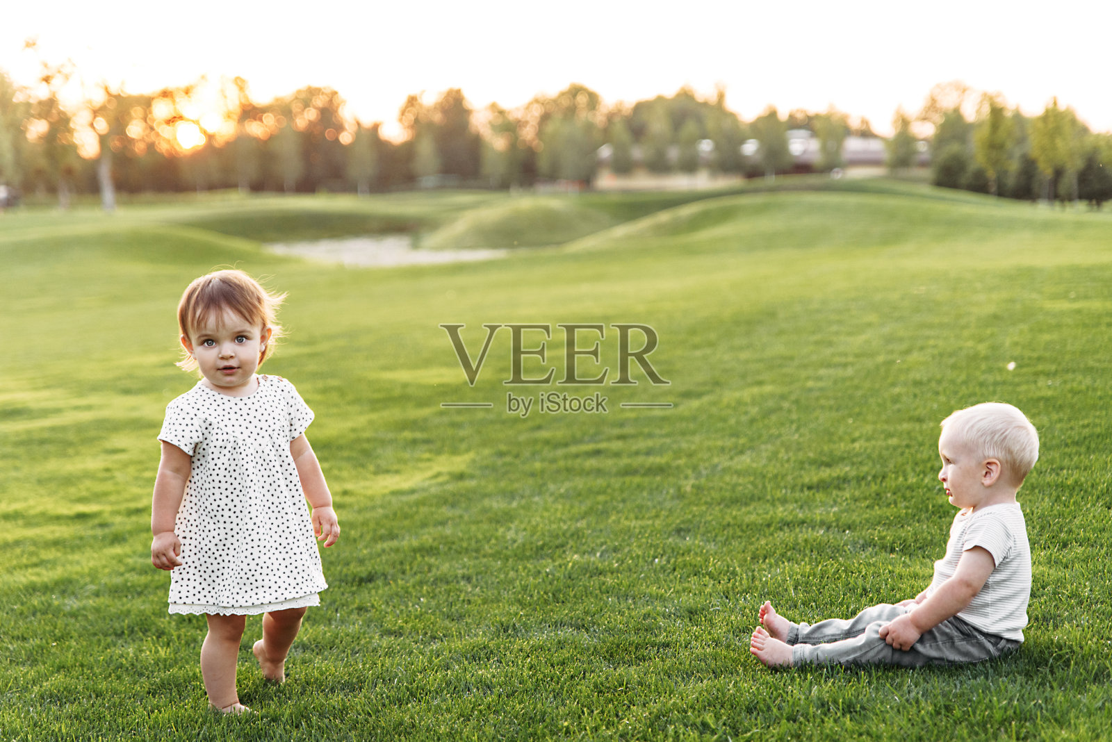 在绿色草地上玩耍的可爱宝宝照片摄影图片