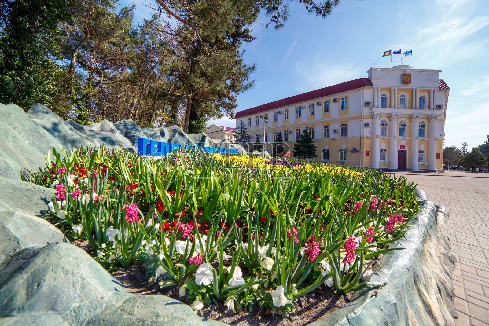 俄罗斯格连齐克——2017年7月20日。城市管理大楼,度假胜地,格伦兹克在一个阳光明媚的日子在前景与鲜花照片摄影图片