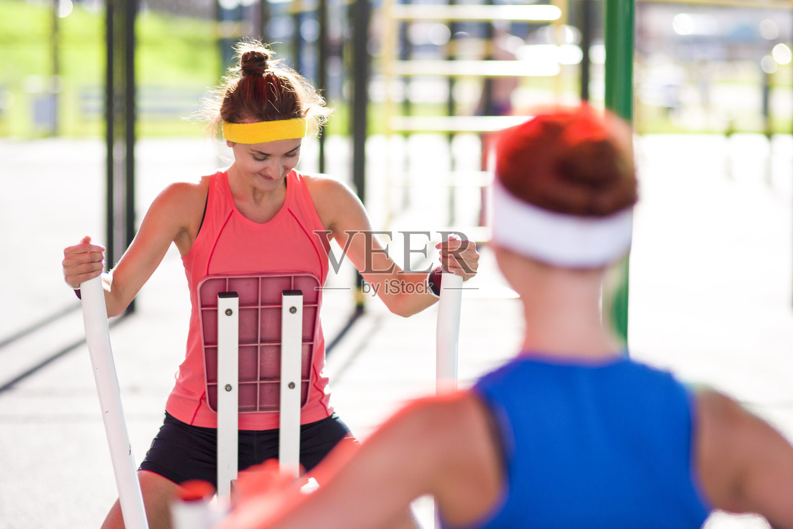 运动理念:两名穿着专业服装的白人女运动员正在进行划船手臂肌肉锻炼照片摄影图片