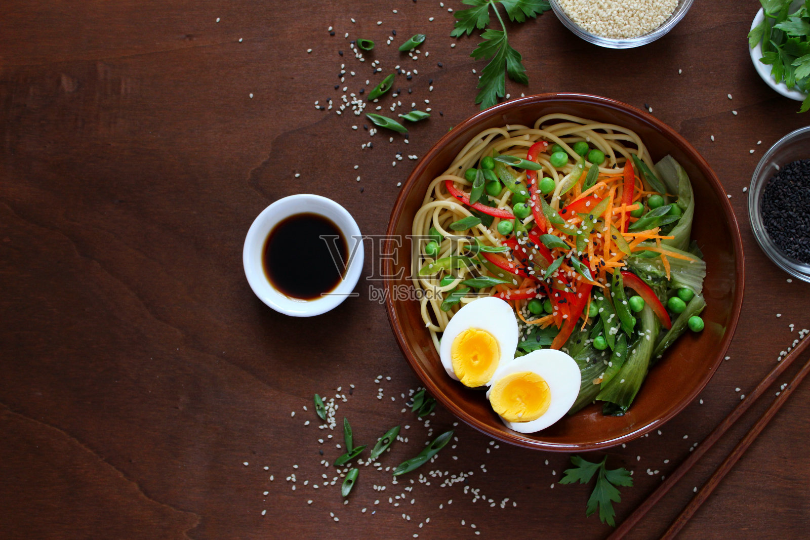 面条与蔬菜和鸡蛋碗在黑暗的背景。照片摄影图片