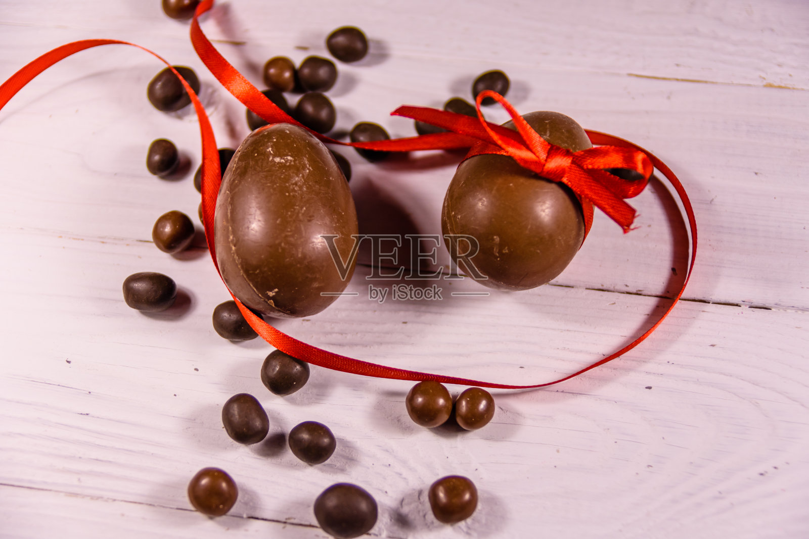白色的木桌上放着巧克力复活节彩蛋。俯视图照片摄影图片