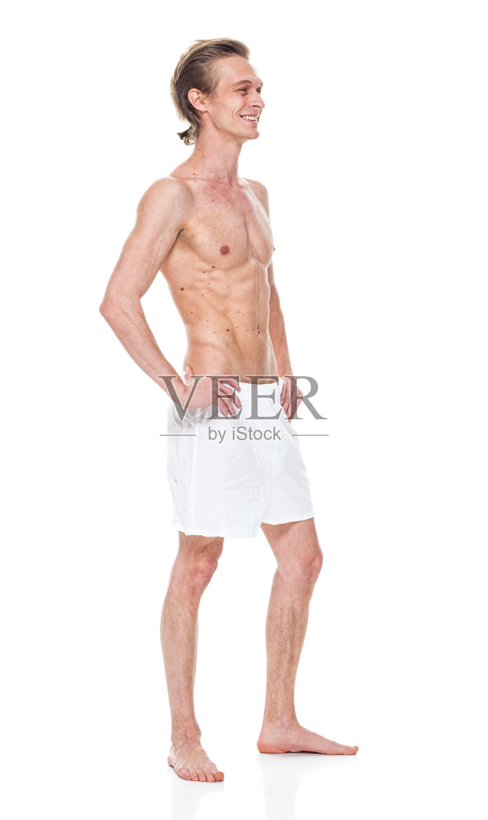白人男性穿着平角短裤站在白色背景前照片摄影图片