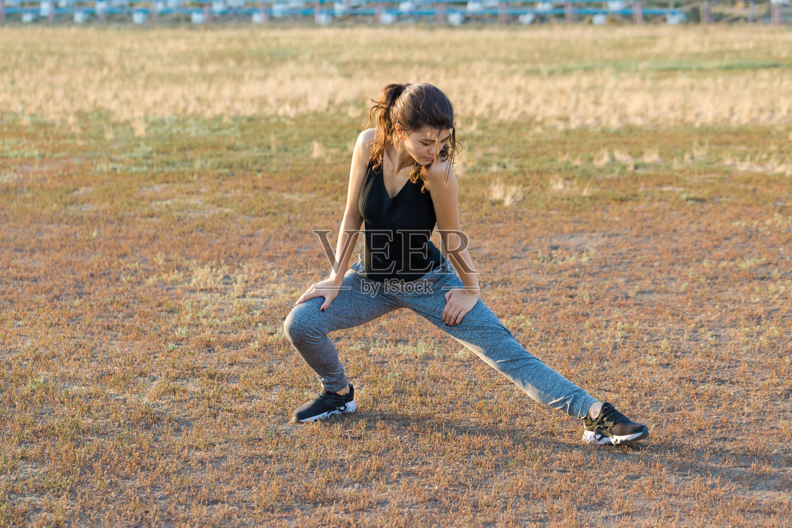 一个年轻苗条的运动女孩穿着印有蛇皮图案的运动服进行一套练习。健康的生活方式。照片摄影图片