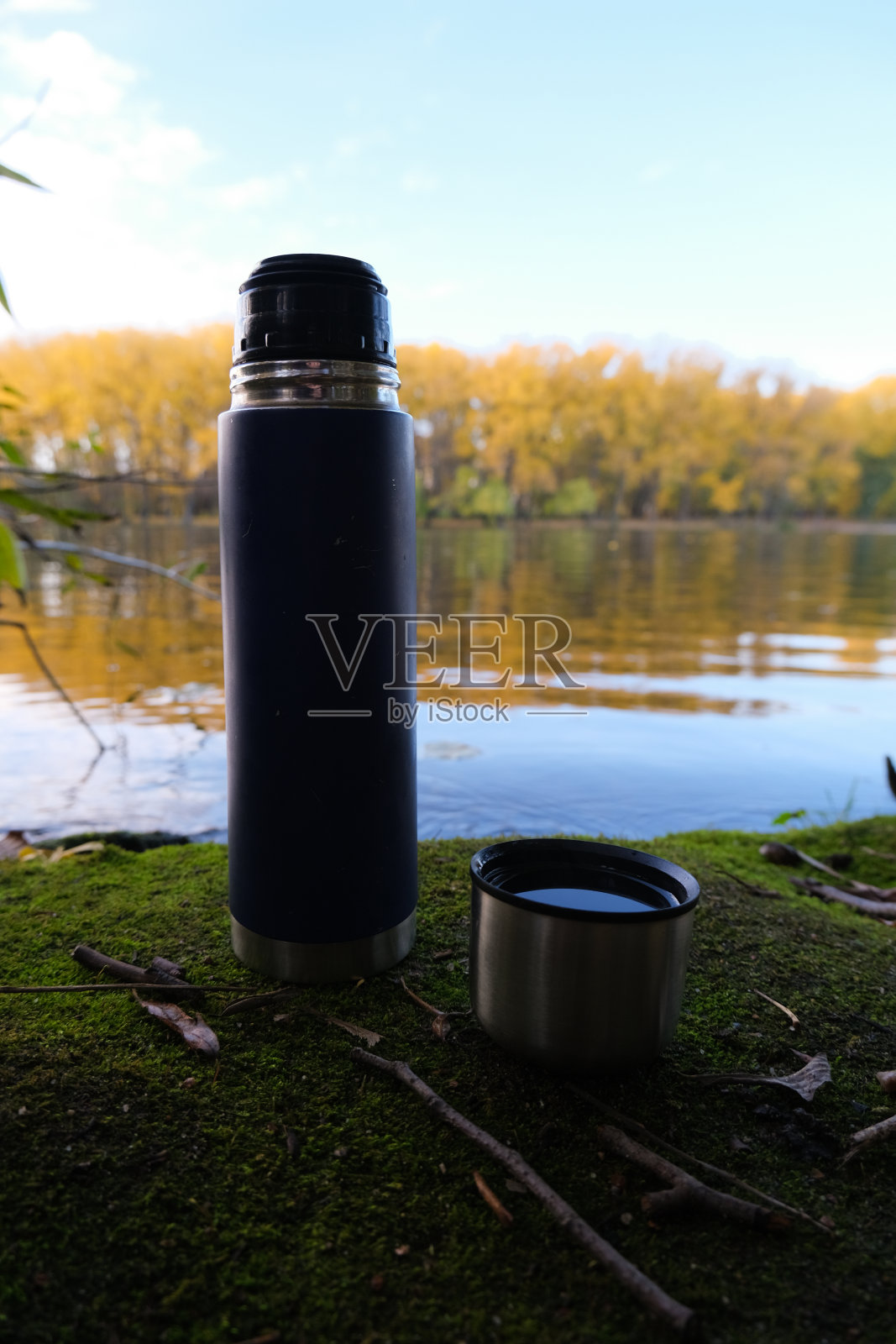 森林和湖泊中的保温瓶。近距离照片摄影图片