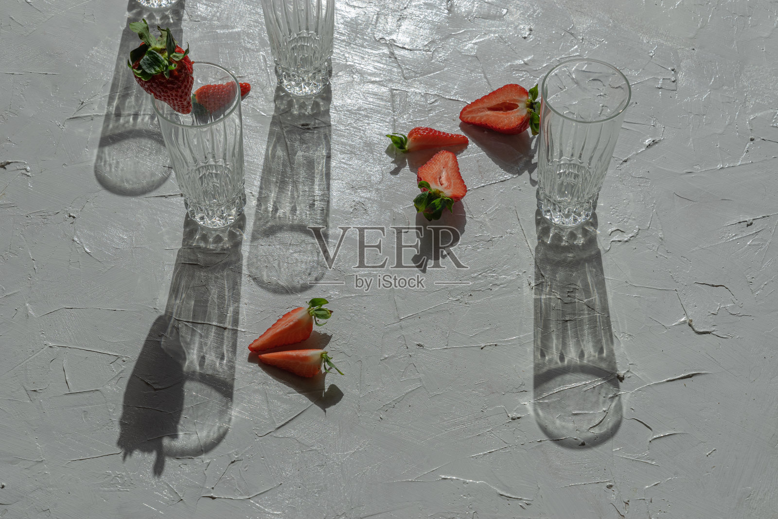 在光线前用草莓和玻璃杯组成照片摄影图片