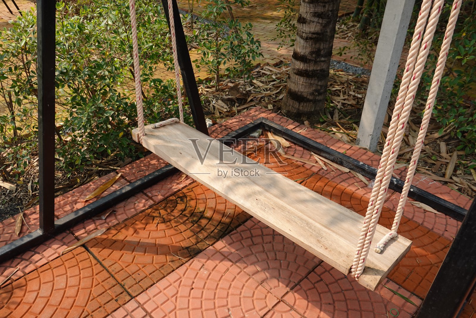 花园里为孩子们悬挂的链条秋千。照片摄影图片