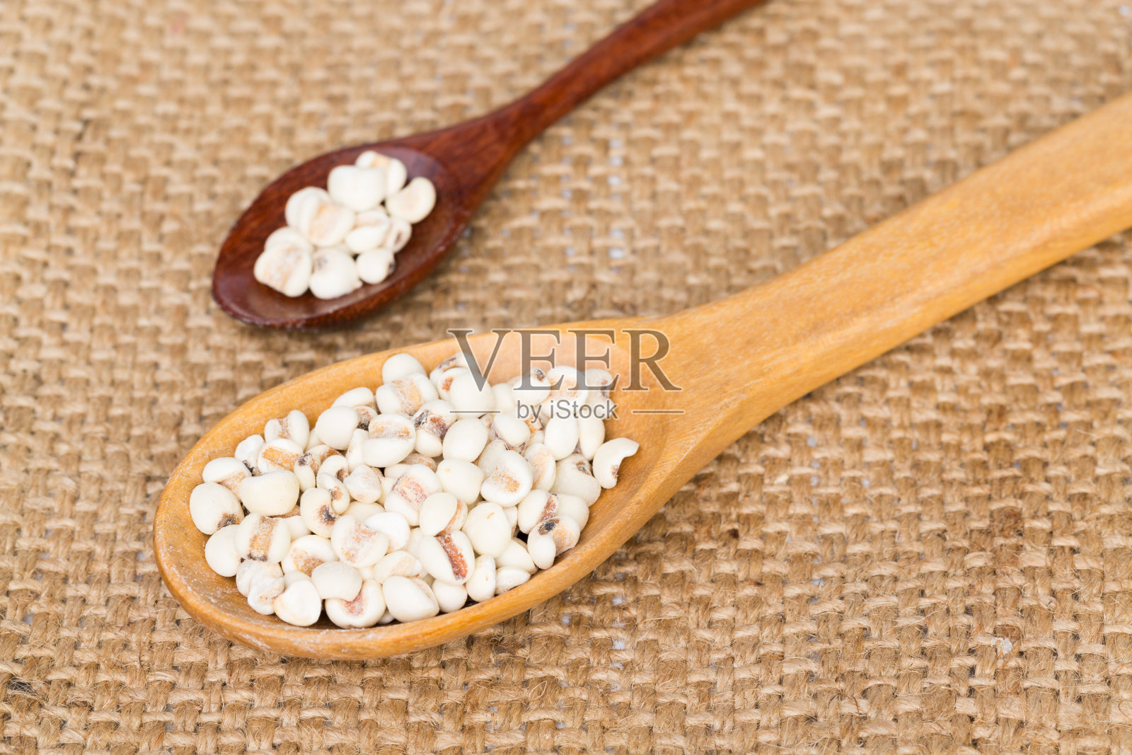 图片近距离小米在勺子木与一个麻袋背景照片摄影图片