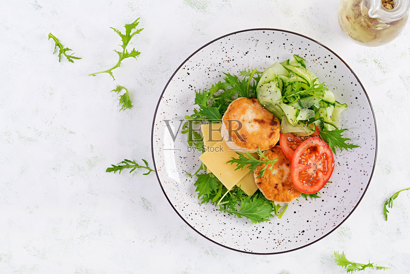 生酮午餐。鸡肉汉堡配番茄、黄瓜、芝士和芝麻菜沙拉,不加面包。鸡肉饼。健康食品。酮/史前饮食。顶视图,开销照片摄影图片
