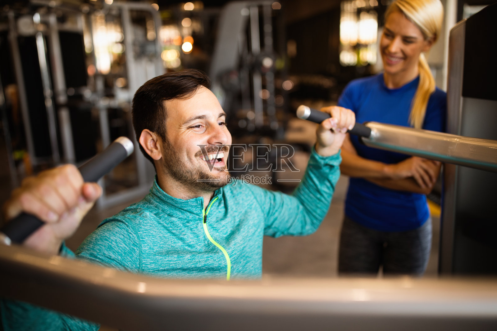 健身房里快乐的男士和私人教练照片摄影图片
