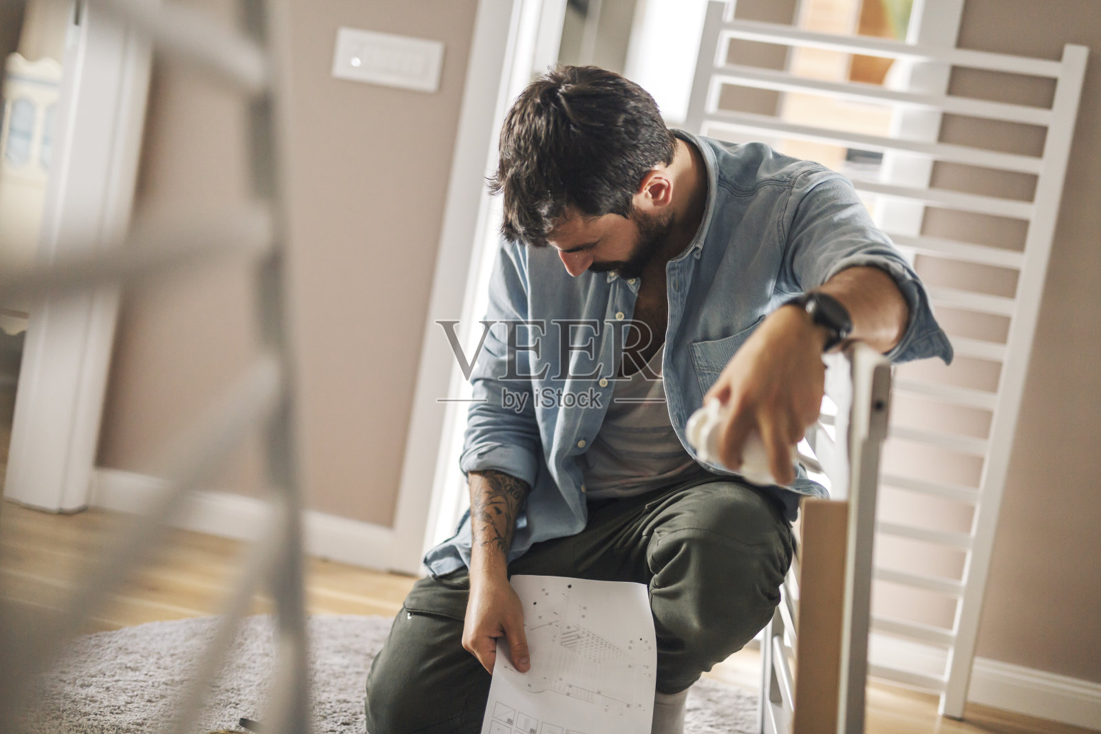 男子试图组装婴儿床照片摄影图片