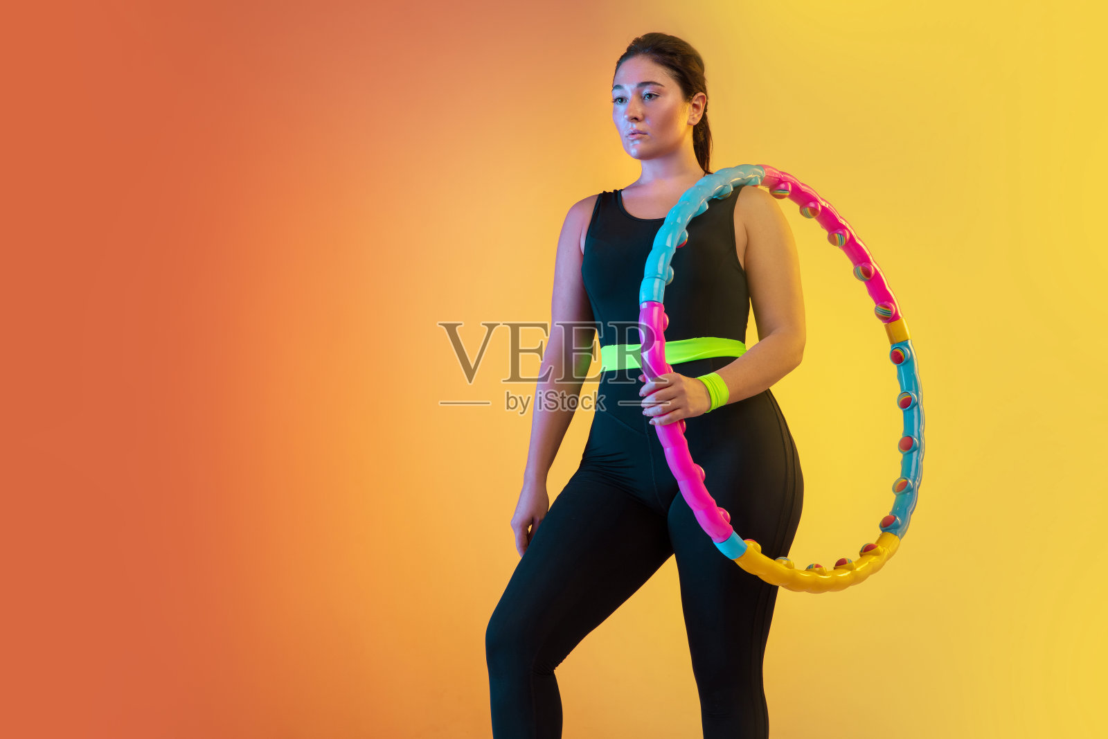 年轻白种人加大尺寸的女性模特在梯度橙色背景训练照片摄影图片