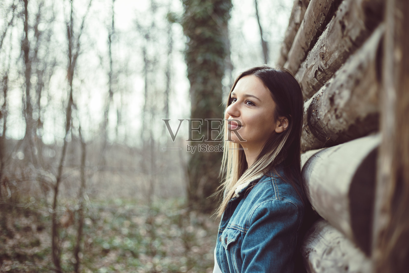 年轻女子倚着农舍摆姿势照片摄影图片