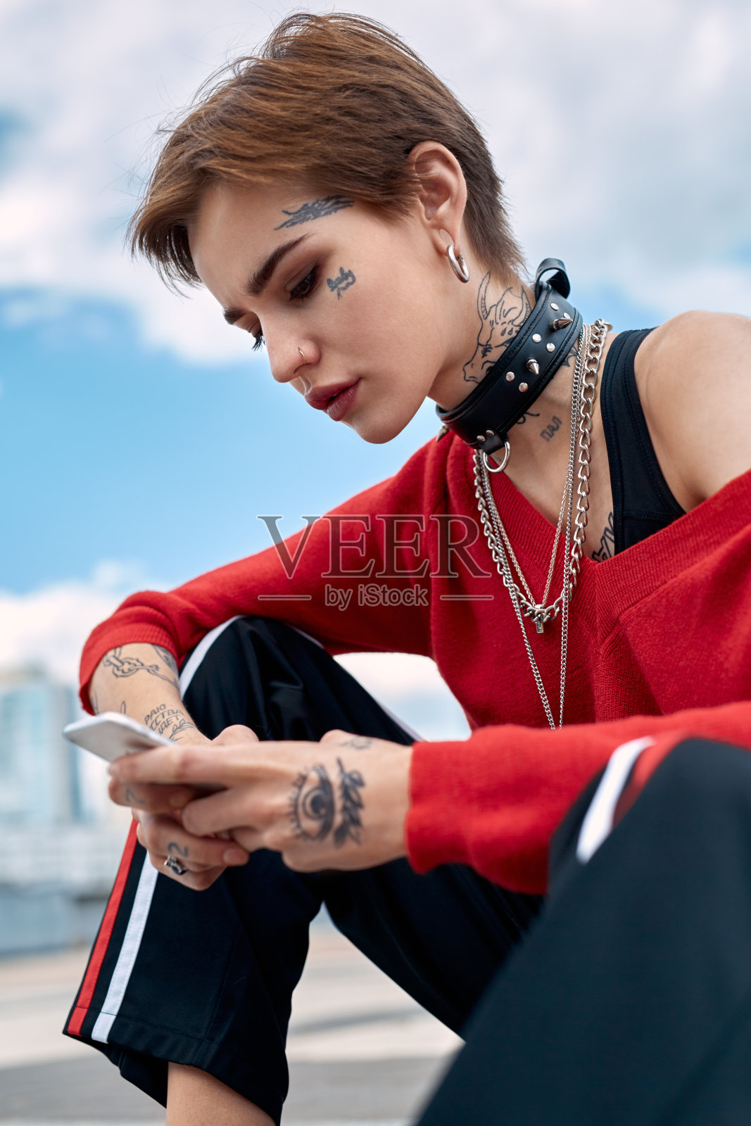 都市时尚:年轻女子户外专注地用智能手机上网照片摄影图片