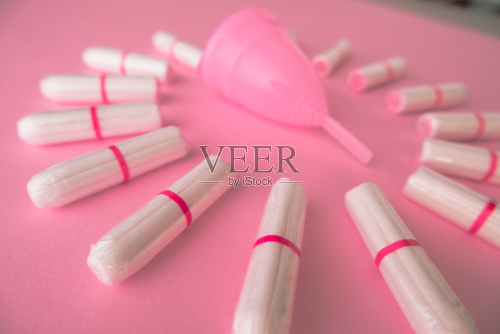 粉色背景的阴道杯和卫生棉条。平躺照片摄影图片