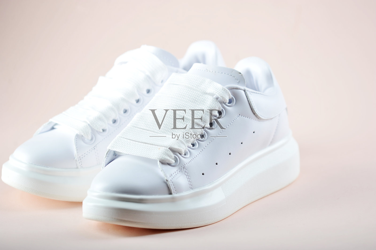 浅色背景上的白人女鞋。侧视图。特写镜头。照片摄影图片