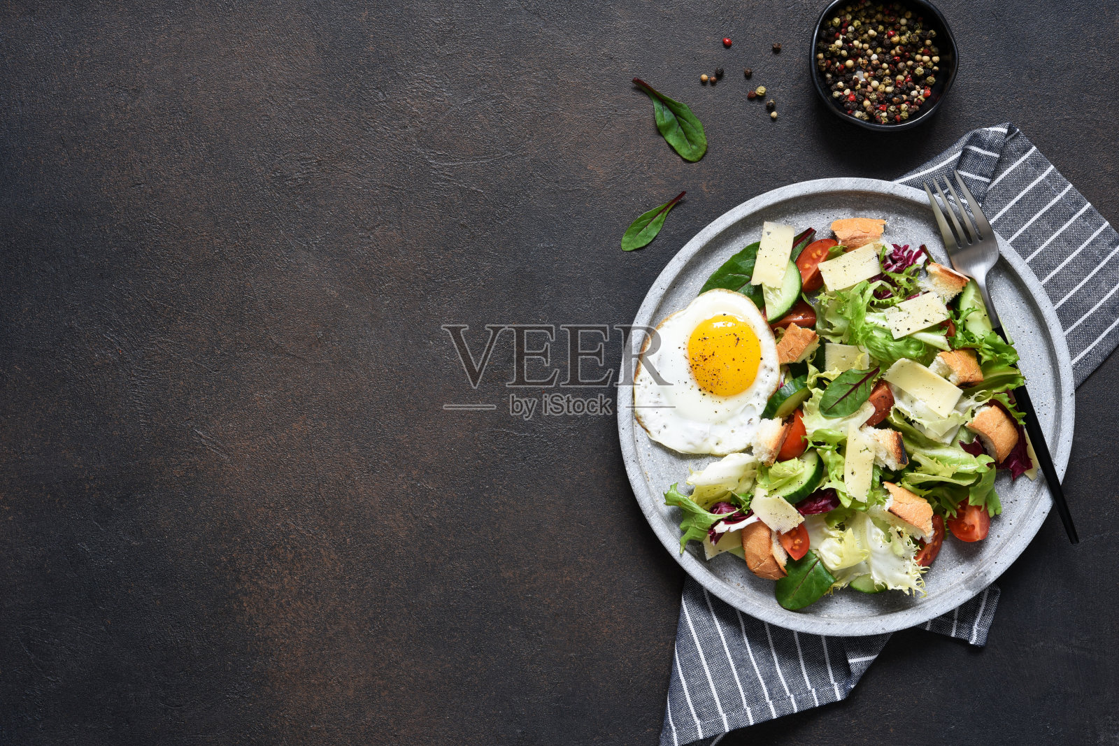 凯撒沙拉配奶酪、饼干和酱汁。混凝土背景上的绿色沙拉。从以上观点。照片摄影图片