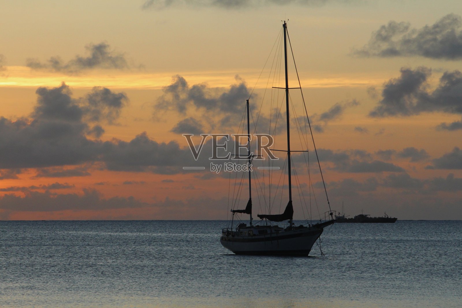 太阳落山后消失在地平线上的帆船的剪影照片摄影图片