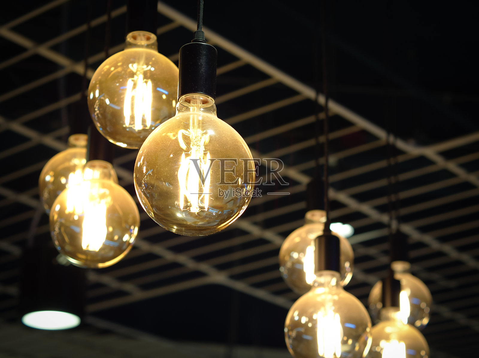 天花板上挂着一个发光的灯泡,是洗手间的背景。照片摄影图片