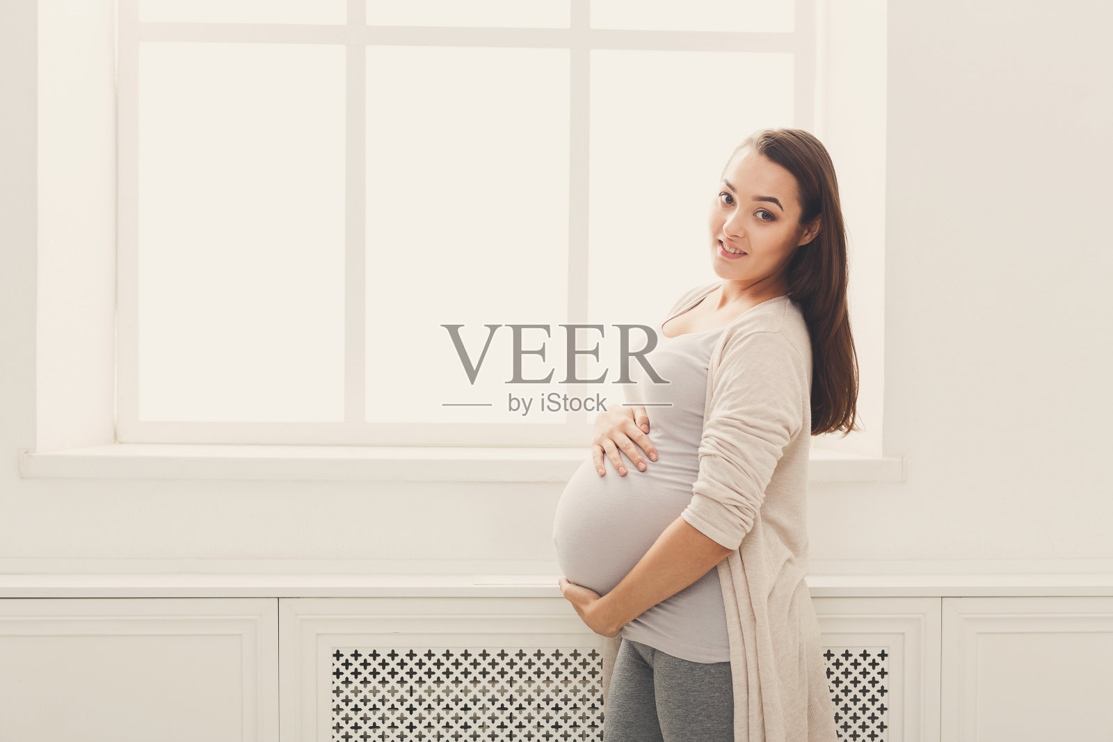 优雅的女人在家里爱抚她的肚子照片摄影图片