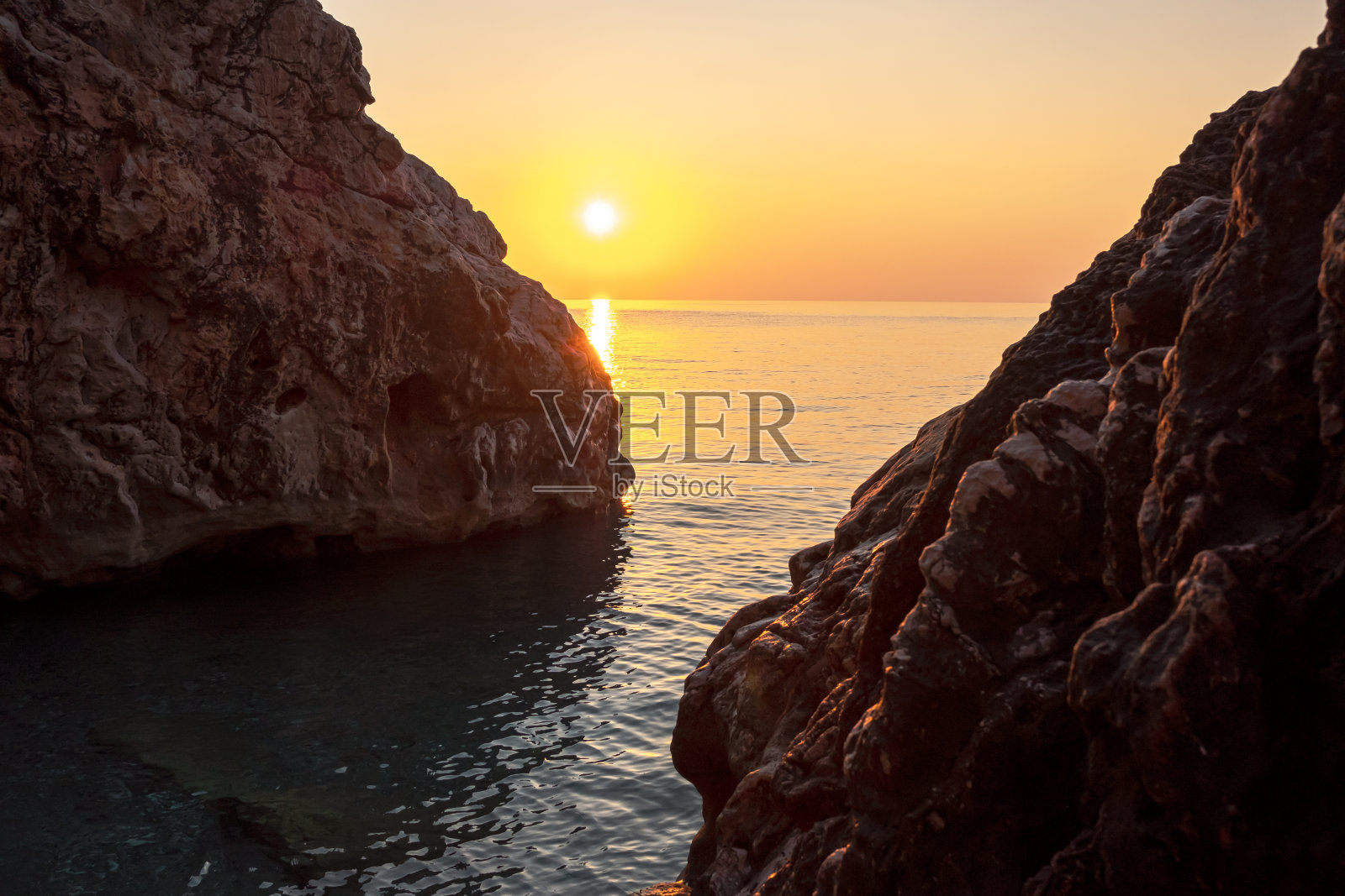 太阳从两块大石头中间升起照片摄影图片
