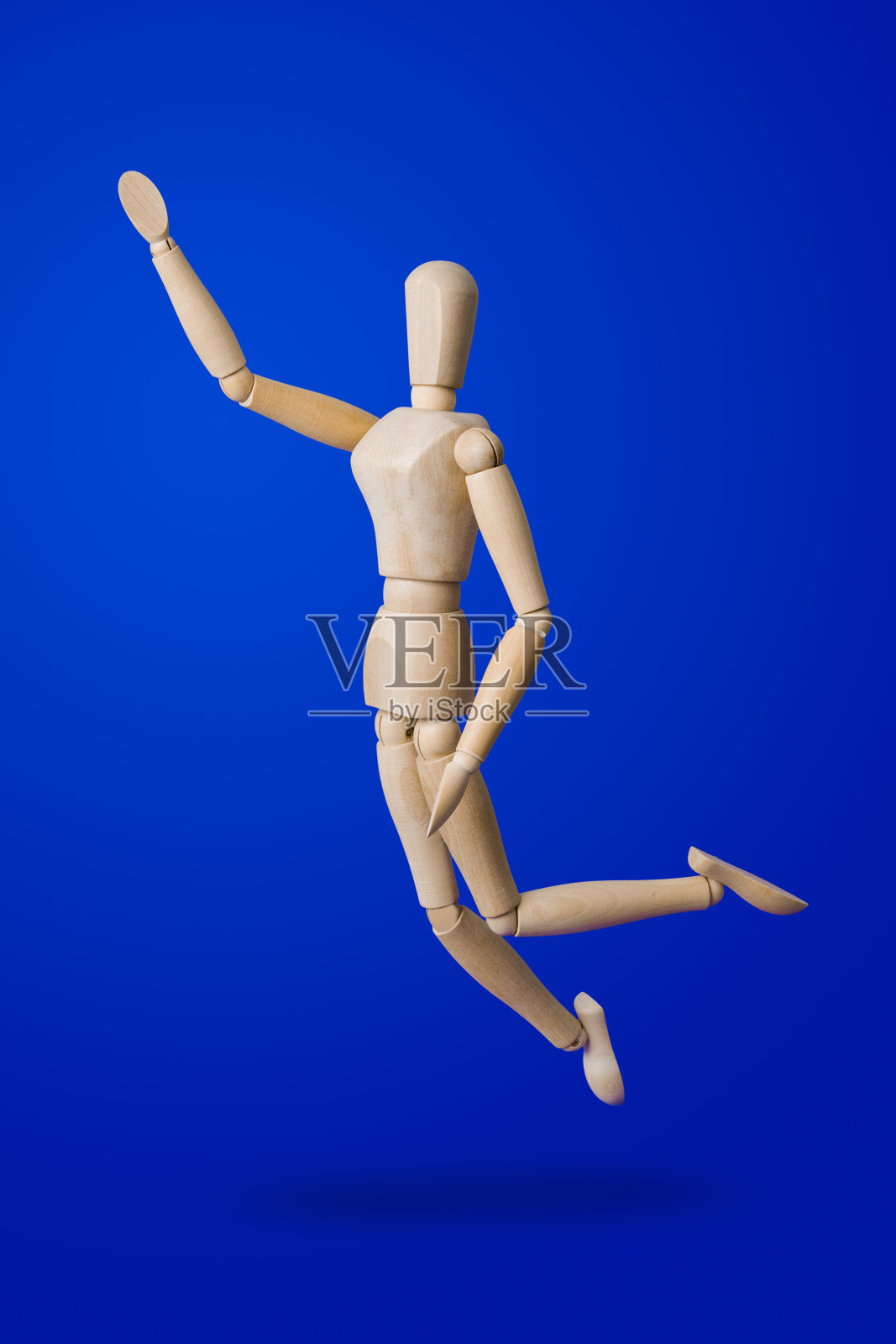 蓝色背景上的运动木制玩具人偶照片摄影图片
